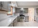 Well-lit kitchen featuring stainless steel appliances, grey cabinets, and white tile countertops at 929 Hammock Shade Dr, Lakeland, FL 33809
