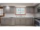 Bright kitchen showcases grey cabinets, tile countertops, and stainless steel appliances at 929 Hammock Shade Dr, Lakeland, FL 33809
