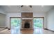 Open living room with a brick fireplace and doors that lead to the screened patio at 929 Hammock Shade Dr, Lakeland, FL 33809