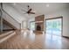 Bright living room with hardwood floors, a brick fireplace, and views of the pool at 929 Hammock Shade Dr, Lakeland, FL 33809