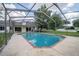 Backyard pool features screen enclosure, brick trim, and a concrete pool deck, perfect for outdoor entertaining at 929 Hammock Shade Dr, Lakeland, FL 33809