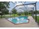 Screen enclosed pool features brick trim, concrete pool deck and views of the grassy backyard at 929 Hammock Shade Dr, Lakeland, FL 33809