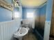 Cozy bathroom featuring a pedestal sink, tub with shower, and light blue walls at 938 E Lowell St, Lakeland, FL 33805