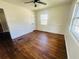 Cozy bedroom featuring hardwood floors, chair railing, and a large window offering natural light at 938 E Lowell St, Lakeland, FL 33805