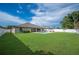 Spacious backyard featuring green lawn, fenced perimeter, pool, and covered patio, offering ample space for outdoor enjoyment at 967 Hunters Meadow Ln, Lakeland, FL 33809