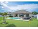 A well-maintained backyard featuring a lush lawn, pool, putting green, and lounge area, perfect for outdoor recreation and relaxation at 967 Hunters Meadow Ln, Lakeland, FL 33809