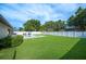 Expansive backyard featuring a well-manicured lawn, white fence, and a sparkling pool with lounge chairs, ideal for outdoor enjoyment at 967 Hunters Meadow Ln, Lakeland, FL 33809