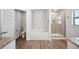 Bright bathroom with a soaking tub, separate shower with glass door, and wood-look floors at 967 Hunters Meadow Ln, Lakeland, FL 33809