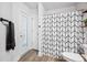 Modern bathroom showcasing a black and white patterned shower curtain and wood-look flooring at 967 Hunters Meadow Ln, Lakeland, FL 33809