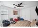 Bright bedroom with a ceiling fan, closet, and multiple seating areas on wood-look floors at 967 Hunters Meadow Ln, Lakeland, FL 33809