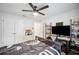 Well-lit bedroom with a ceiling fan, desk, and closet doors on wood-look floors at 967 Hunters Meadow Ln, Lakeland, FL 33809