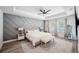 Main bedroom boasts tray ceiling, modern accent wall, ceiling fan, and cozy furniture at 967 Hunters Meadow Ln, Lakeland, FL 33809