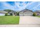 Lovely home exterior with a well-manicured lawn, featuring a three-car garage and inviting landscaping at 967 Hunters Meadow Ln, Lakeland, FL 33809