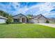 Beautiful front yard with lush green grass and a well-maintained exterior, featuring a three-car garage at 967 Hunters Meadow Ln, Lakeland, FL 33809