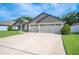 Spacious three-car garage exterior with a wide driveway and manicured lawn, offering ample parking at 967 Hunters Meadow Ln, Lakeland, FL 33809