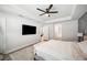 Spacious main bedroom with a ceiling fan, tray ceiling, mounted television, and neutral walls at 967 Hunters Meadow Ln, Lakeland, FL 33809