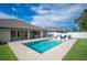 Inviting backyard featuring a refreshing pool, outdoor kitchen, and lush lawn area at 967 Hunters Meadow Ln, Lakeland, FL 33809