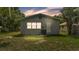 Cozy home backyard features a well-maintained lawn, window, door and modern air conditioning unit at 980 S Mill Ave, Bartow, FL 33830