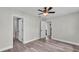 Bright bedroom with ceiling fan and wood-look flooring, leading to bathroom and closet spaces at 980 S Mill Ave, Bartow, FL 33830