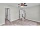 Bright bedroom with ceiling fan and wood-look flooring, leading to bathroom and closet spaces at 980 S Mill Ave, Bartow, FL 33830