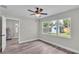 Bedroom featuring wood-look floors, three sunny windows, and a view to a backyard at 980 S Mill Ave, Bartow, FL 33830