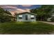 Quaint home at dusk with freshly cut lawn, new paint, and charming window boxes at 980 S Mill Ave, Bartow, FL 33830