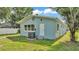The back exterior of this light blue home showcases a door, air conditioning unit, and yard at 980 S Mill Ave, Bartow, FL 33830
