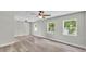 Spacious living room with wood-look floors, ceiling fans, and large windows at 980 S Mill Ave, Bartow, FL 33830