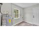 Utility room with grey wood-look floors, water heater, and window with outdoor view at 980 S Mill Ave, Bartow, FL 33830