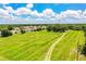 Aerial view of the home surrounded by a lush green field, and neighboring homes in the distance at 10 Webb Rd, Winter Haven, FL 33881