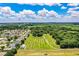 Aerial of a sprawling green property with nearby homes, trees, and a scenic view of the distant landscape at 10 Webb Rd, Winter Haven, FL 33881
