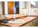 Bathroom featuring dual sinks with unique faucets, and patterned countertops against coordinating wallpaper at 10 Webb Rd, Winter Haven, FL 33881