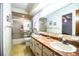 Bathroom featuring dual sinks, a shower with sliding doors, and vintage wallpaper, offering a blend of comfort at 10 Webb Rd, Winter Haven, FL 33881