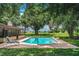 Inviting backyard pool with lush landscaping and a screened-in patio for relaxing and entertaining at 10 Webb Rd, Winter Haven, FL 33881