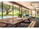 Enclosed pool area with ceiling fans and picnic table, overlooking lush greenery at 10 Webb Rd, Winter Haven, FL 33881