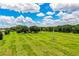 Aerial view of the property showcasing a sprawling green field, and a central house at 10 Webb Rd, Winter Haven, FL 33881