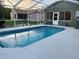Backyard pool surrounded by a screened enclosure and patio at 1011 Tequesta Trl, Lake Wales, FL 33898
