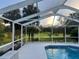 View of the pool and lush backyard scenery through the screened enclosure at 1011 Tequesta Trl, Lake Wales, FL 33898