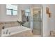 Bathroom featuring soaking tub and glass-enclosed shower at 1028 15Th Ne St, Winter Haven, FL 33881