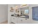Bright bathroom with double sinks, white cabinets, and decorative shelves at 1028 15Th Ne St, Winter Haven, FL 33881