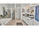 Bright bathroom featuring double sinks, decorative shelves, a tub, and a glass-enclosed shower at 1028 15Th Ne St, Winter Haven, FL 33881