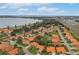 Community aerial view showcasing homes with terracotta roofs and nearby lake and highway at 104 Morning Glory Cir, Winter Haven, FL 33884