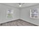 Bright bedroom with two windows for natural light and light toned wood-look flooring at 1050 Reynolds Rd, Lakeland, FL 33801