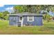 Side of home, featuring a back door, air conditioning unit, and white trim windows at 1050 Reynolds Rd, Lakeland, FL 33801
