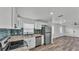 Bright kitchen featuring stainless steel appliances, blue tile backsplash and wood-look flooring at 1050 Reynolds Rd, Lakeland, FL 33801