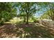 Expansive backyard featuring mature trees, a chain-link fence and a newer white vinyl fence for privacy at 114 Ed Padgett Rd, Lakeland, FL 33809