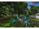 The backyard features a welcoming fire pit and a canopy of lush, mature trees at 114 Ed Padgett Rd, Lakeland, FL 33809