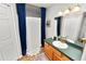 Well-lit bathroom featuring a sink, vanity, mirror, and shower with stylish blue curtains at 114 Ed Padgett Rd, Lakeland, FL 33809