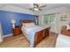 Cozy bedroom with wood floors, a blue accent wall, and natural light from a window at 114 Ed Padgett Rd, Lakeland, FL 33809