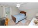 A sunny bedroom is furnished with a bed, side table, a desk, and a ceiling fan at 114 Ed Padgett Rd, Lakeland, FL 33809
